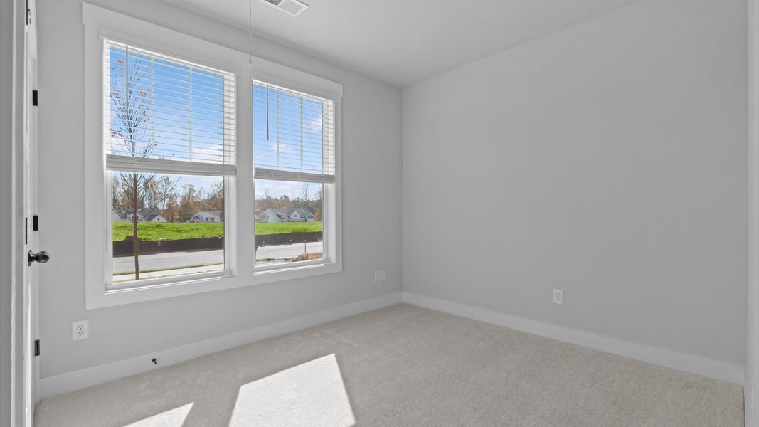 Vibrant and restful bedroom with oversized windows, refined detail, and a warm, welcoming atmosphere