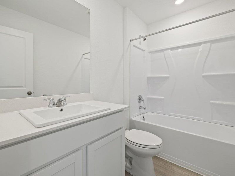 Full bathroom with shower / washtub combination, vanity, and light wood finished floors