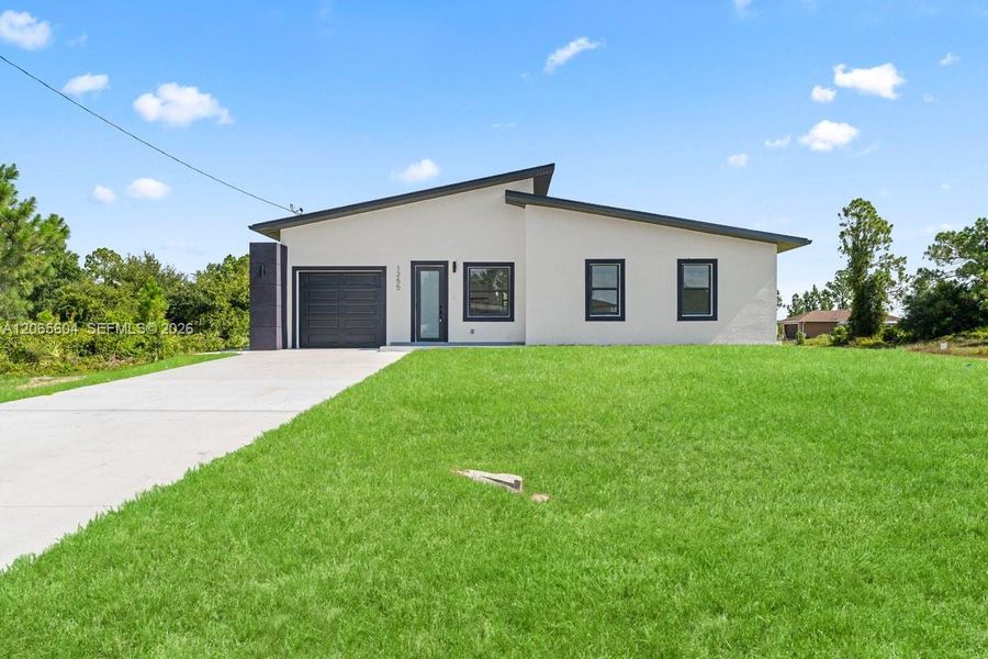 Front exterior of a new home in , Lehigh Acres, FL, highlighting curb appeal (Image 18). Front exterior of a new home in , Lehigh Acres, FL, highlighting curb appeal (Image 18).