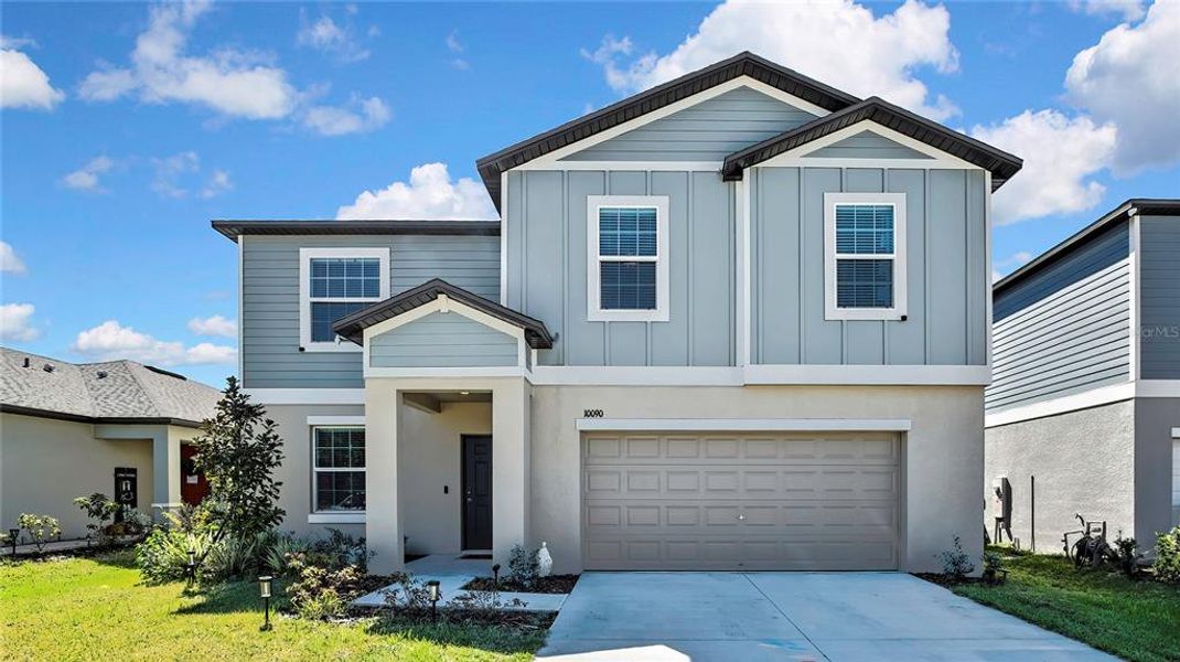 Front exterior of a new home in Angeline: The Estates, Land O' Lakes, FL, highlighting curb appeal (Image 2).