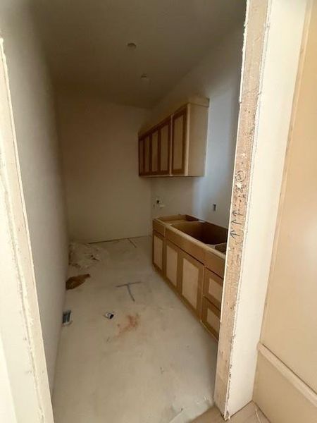 Tiled laundry room will offer space for full size washer/dryer, cabinets and counter with sink and storage.