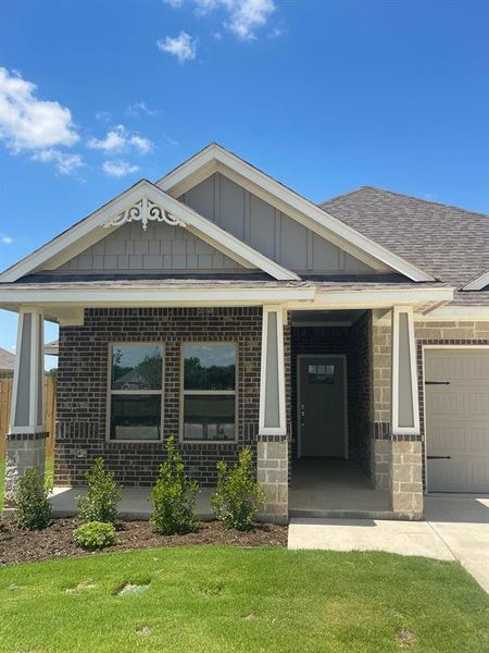 View of front of property with a garage and a front lawn