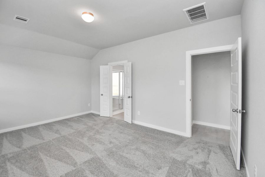 Escape and relax in the exquisite primary suite, a haven to unwind after a long day. The spacious room, boasts plush carpeting, soothing paint tones, high ceilings, and expansive windows adorned with privacy blinds.