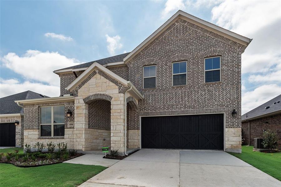 Front exterior of a new home in Spiritas Ranch, Little Elm, TX, highlighting curb appeal (Image 2).