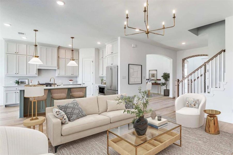 Living room featuring stairs, recessed lighting, light wood-style floors, and a chandelier Living room featuring stairs, recessed lighting, light wood-style floors, and a chandelier