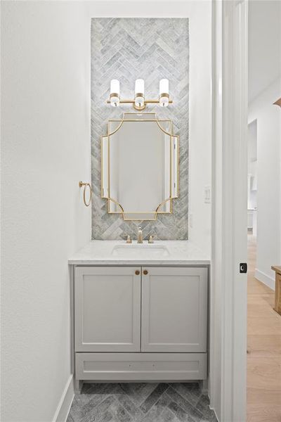 Bathroom featuring vanity and tasteful backsplash
