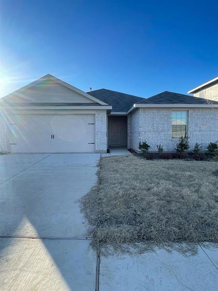 Ranch-style house featuring a garage and a front yard