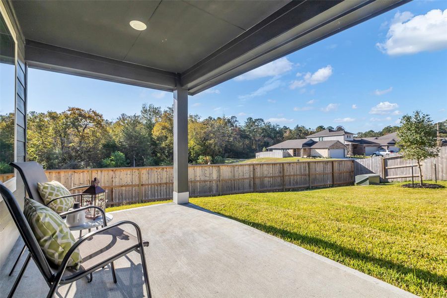 The covered back patio overlooks the wooded common ground.