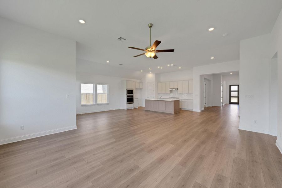 Unfurnished living room with ceiling fan, recessed lighting, plenty of natural light, and light wood-style flooring