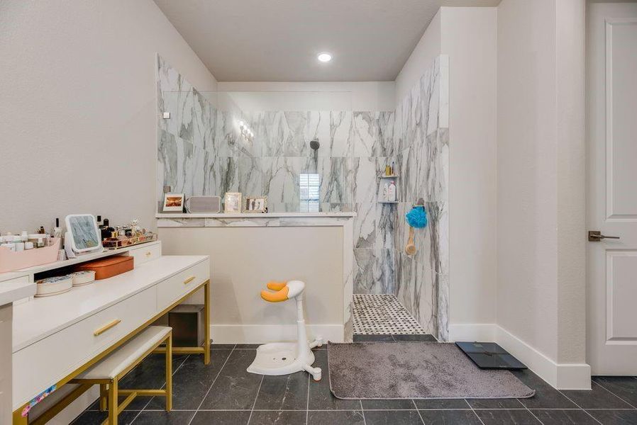 Full bathroom with a marble finish shower and baseboards