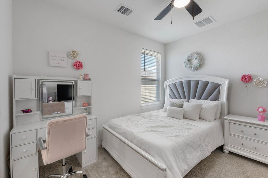 Bedroom 2 featuring visible vents, light carpet, and ceiling fan