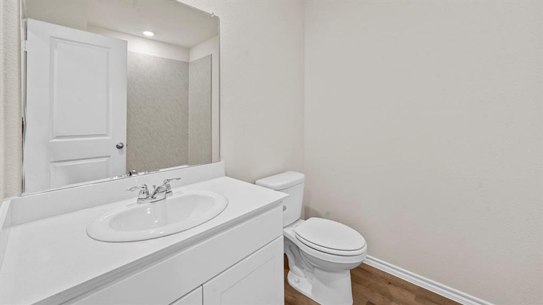 Half bath featuring vanity and dark wood-style flooring