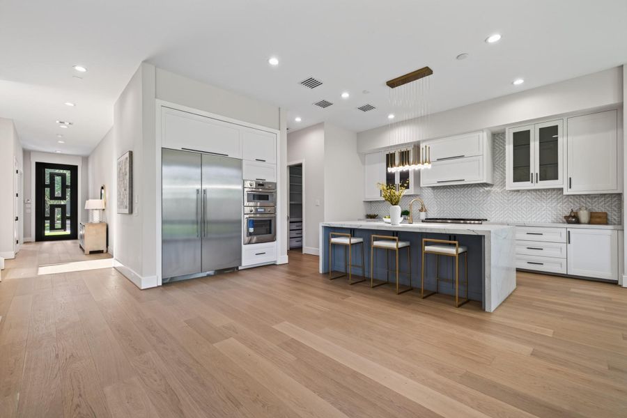 Expansive kitchen island with seating, wrapped in white quartz for a bright, airy feel.