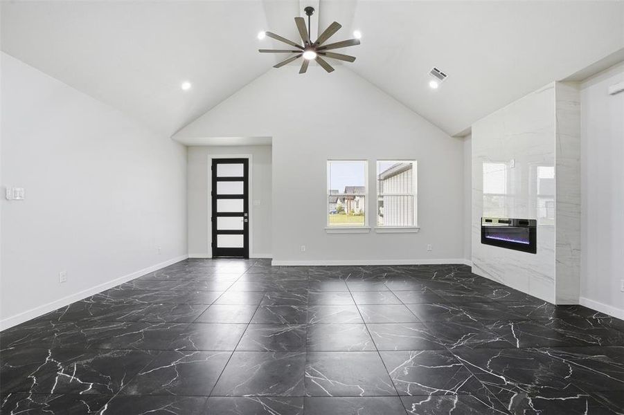 Spacious living area featuring vaulted ceilings, recessed lighting, and a modern ceiling fan