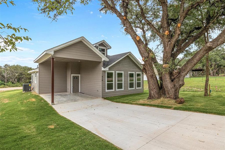 View of front of house with a front lawn and central air condition unit