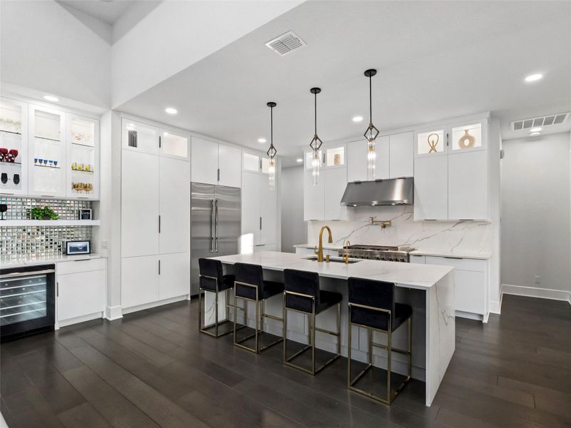Kitchen featuring tasteful backsplash, beverage cooler, white cabinets, and stainless steel appliances