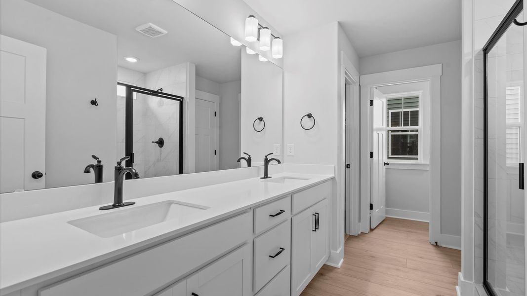 Exceptional en-suite with dual vanity and glass-enclosed tiled walk-in shower for superior everyday comfort