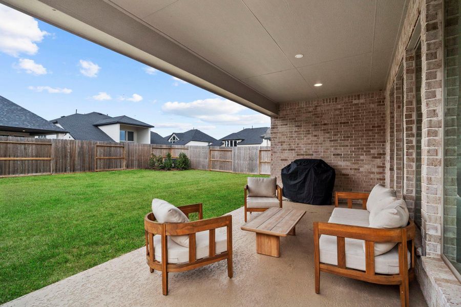 Covered back patio with recessed lighting and textured concrete, perfect for outdoor lounging and entertaining. Covered back patio with recessed lighting and textured concrete, perfect for outdoor lounging and entertaining.