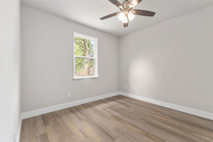 Empty room featuring ceiling fan and hardwood / wood-style flooring