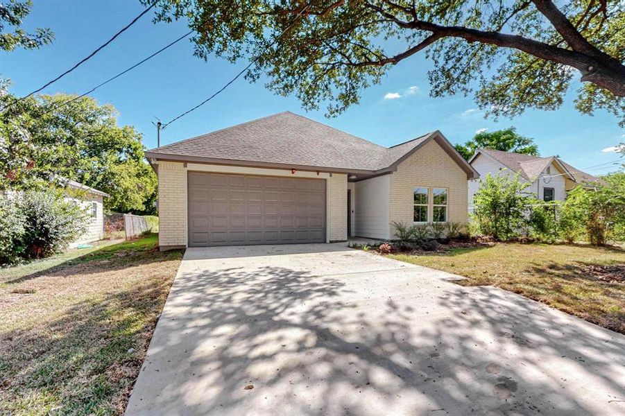 View of front of home with a front yard and a garage