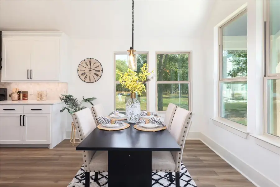 Dining room with dark wood-type flooring and baseboards