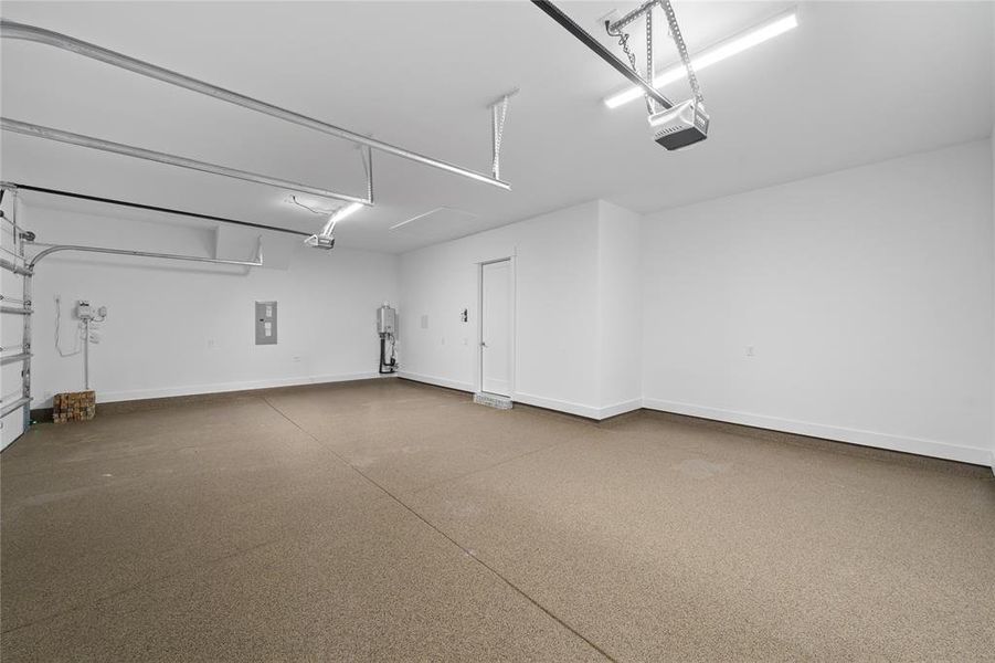 Spacious garage with epoxy flooring, white walls, and bright overhead lighting