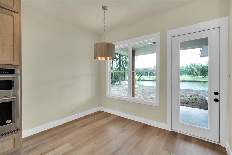 Unfurnished dining area featuring light hardwood / wood-style flooring and a water view