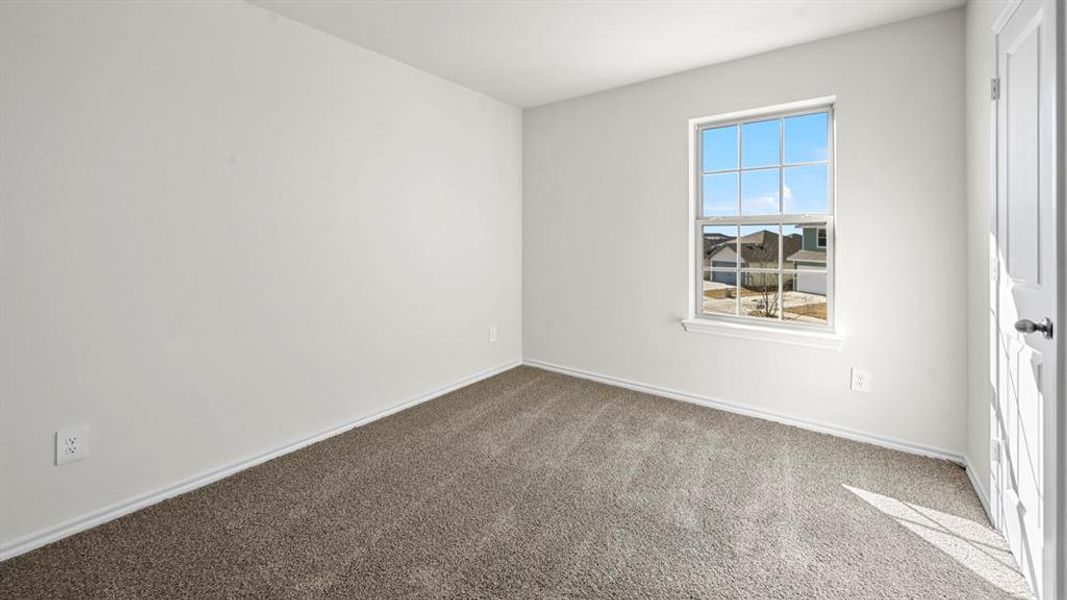 Neutral white wall paint, grey carpet flooring, white trim, and a window with grid panes