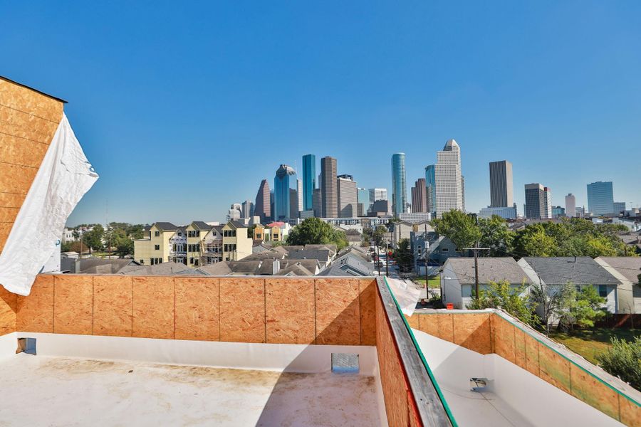 This photo showcases a rooftop view from a home under construction, offering a clear sight of the city skyline. The area is surrounded by residential neighborhoods, providing a blend of urban and suburban living. This photo showcases a rooftop view from a home under construction, offering a clear sight of the city skyline. The area is surrounded by residential neighborhoods, providing a blend of urban and suburban living.