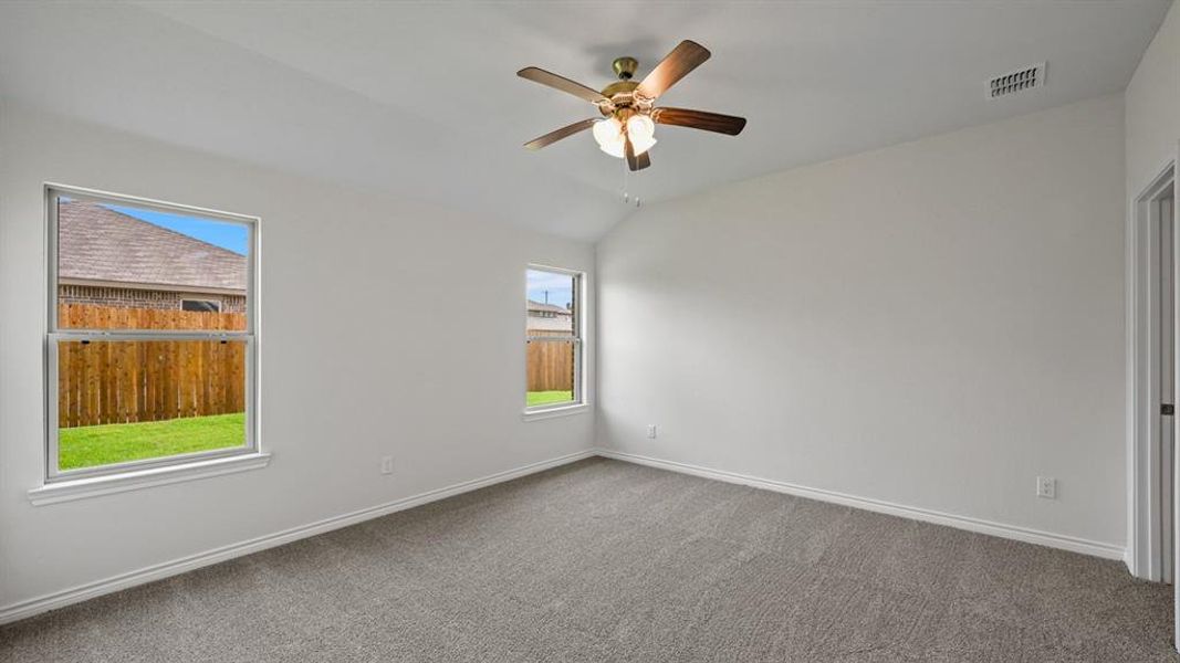 Carpeted interior room featuring light-toned walls, white trim, and two double-hung windows Carpeted interior room featuring light-toned walls, white trim, and two double-hung windows
