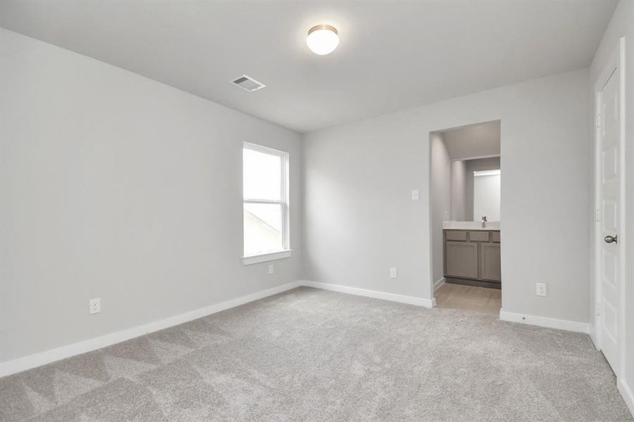 Secondary bedroom features plush carpet, custom paint, large window with privacy blinds and access to the Jack and Jill bath. Sample photo of completed home with similar floor plan. Actual colors and selections may vary.