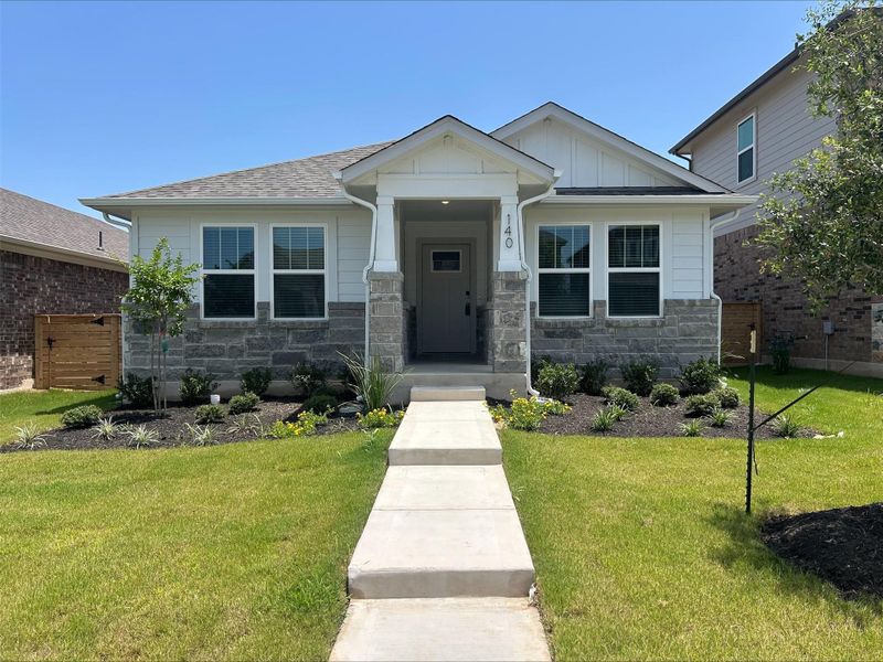 Craftsman-style house featuring stone siding, board and batten siding, and a front lawn Craftsman-style house featuring stone siding, board and batten siding, and a front lawn