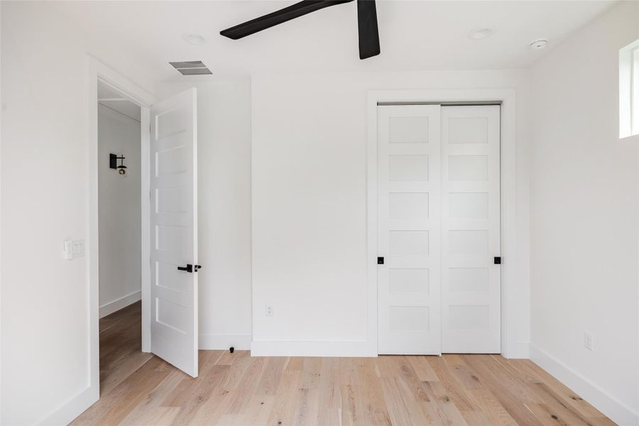 Another beautifully designed bedroom with fresh, crisp paint, a ceiling fan, and recessed lighting, offering a serene and modern atmosphere perfect for rest and relaxation.