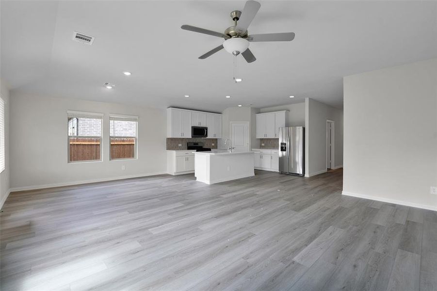 Unfurnished living room with recessed lighting, light wood finished floors, and ceiling fan Unfurnished living room with recessed lighting, light wood finished floors, and ceiling fan