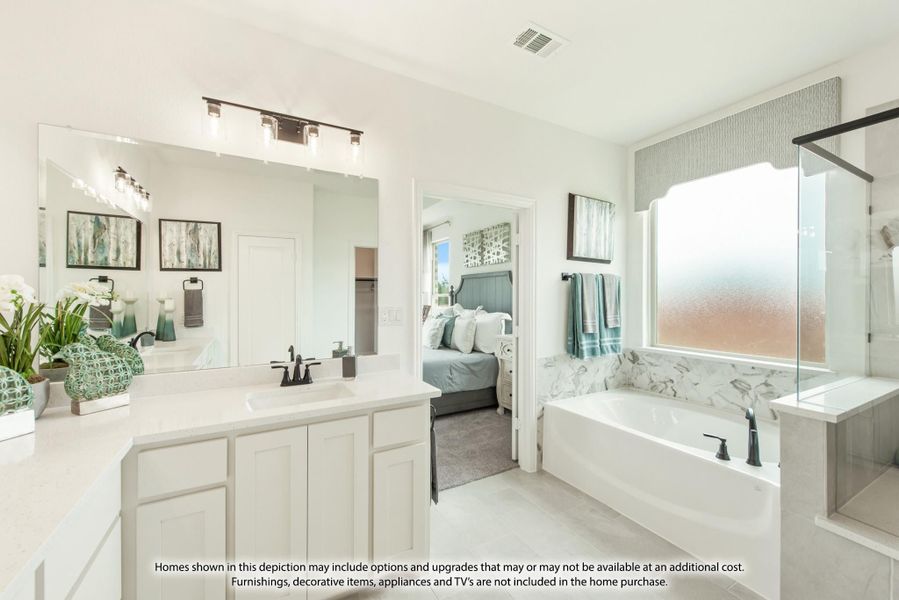 Master bathroom with white vanity, soaking tub with marble surround, and glass shower enclosure