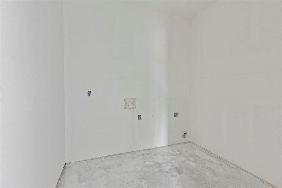 Unfinished room featuring white walls, concrete flooring, and visible electrical outlets Unfinished room featuring white walls, concrete flooring, and visible electrical outlets