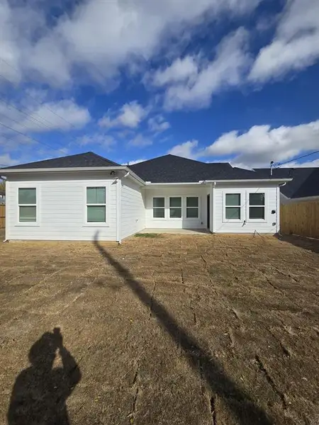 Rear view of property with a patio and roof with shingles
