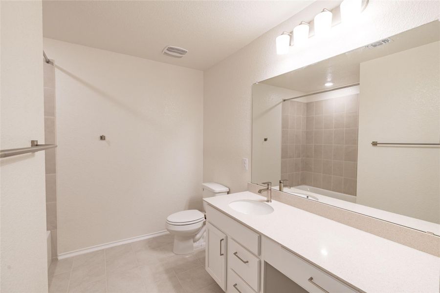 Modern bath offering a full vanity with ample counter space and a clean-lined bathtub. Modern bath offering a full vanity with ample counter space and a clean-lined bathtub.