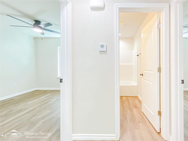 Hallway with light wood-style floors and baseboards Hallway with light wood-style floors and baseboards
