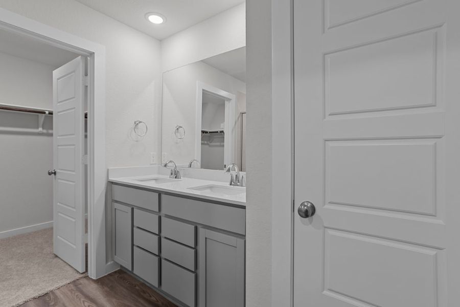 A bathroom with white cabinets.