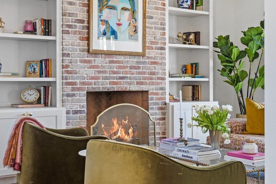 Sitting room with built in features and a brick fireplace