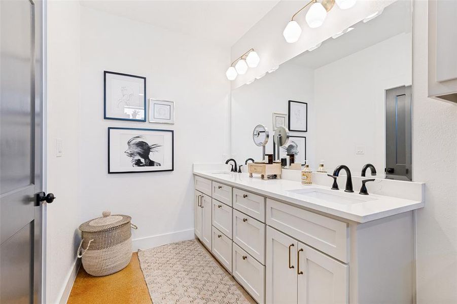 Double vanity with white cabinetry, matte black hardware, and integrated sinks Double vanity with white cabinetry, matte black hardware, and integrated sinks