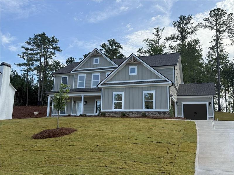 Front exterior of a new home in Woodland Hills, Loganville, GA, highlighting curb appeal (Image 1). Front exterior of a new home in Woodland Hills, Loganville, GA, highlighting curb appeal (Image 1).