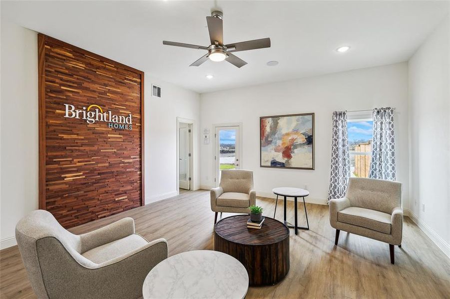 Spacious interior room featuring a decorative wood wall, wood-finish flooring, recessed lighting, and a ceiling fan