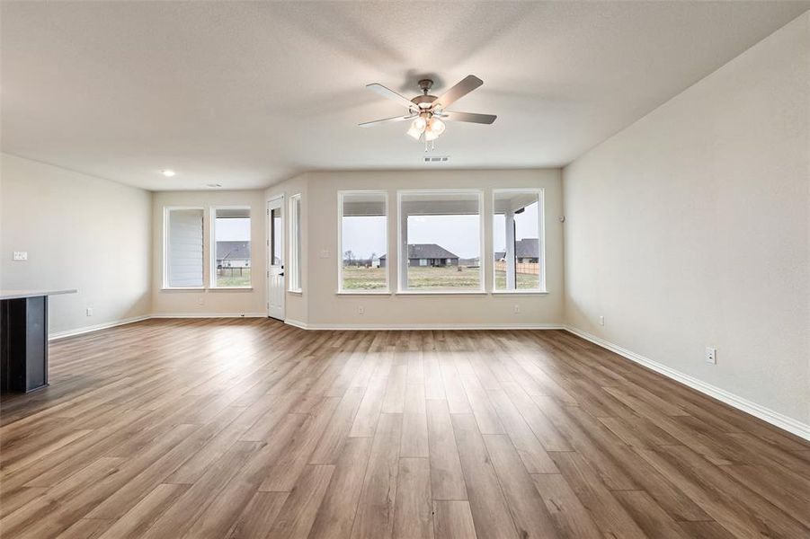 Unfurnished living room featuring light wood-style flooring and a ceiling fan