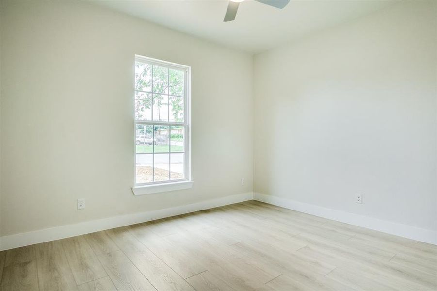 Spare room with baseboards, a ceiling fan, and wood finished floors