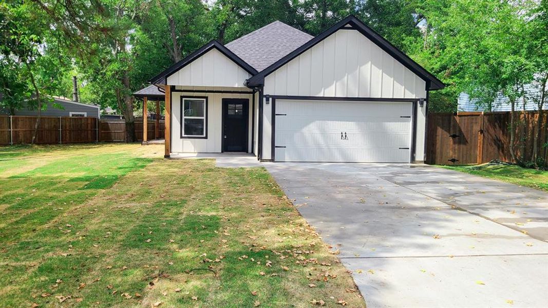 View of front of property with a garage and a front lawn