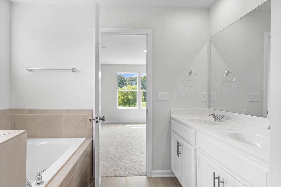 A bathroom with a tub sink and a shower unit. A bathroom with a tub sink and a shower unit.