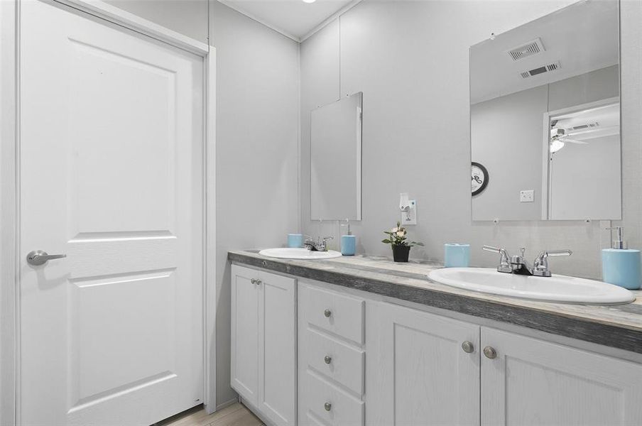 Full bath featuring double vanity and a ceiling fan Full bath featuring double vanity and a ceiling fan