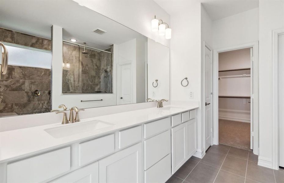 Elegant owner's bathroom with dual vanity and oversized shower*real home pictured